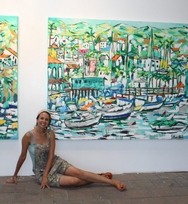 artist Brooke Harker being a mermaid next to paintings