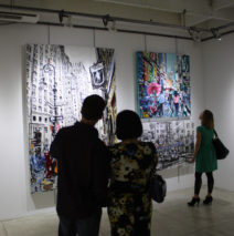 couple viewing original paintings by Brooke Harker