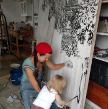 Brooke Harker paints with a toddler assistant