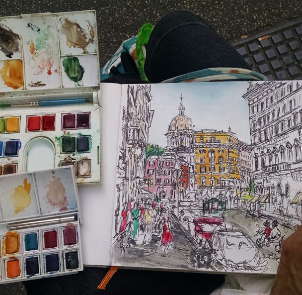 art supplies with a watercolor sketch of Rome, Italy