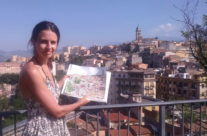 artist Brooke Harker with watercolor of Frosinone, Italy